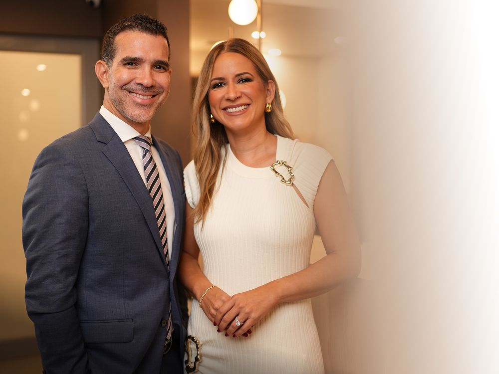 Smiling couple in formal attire, happy expression.
