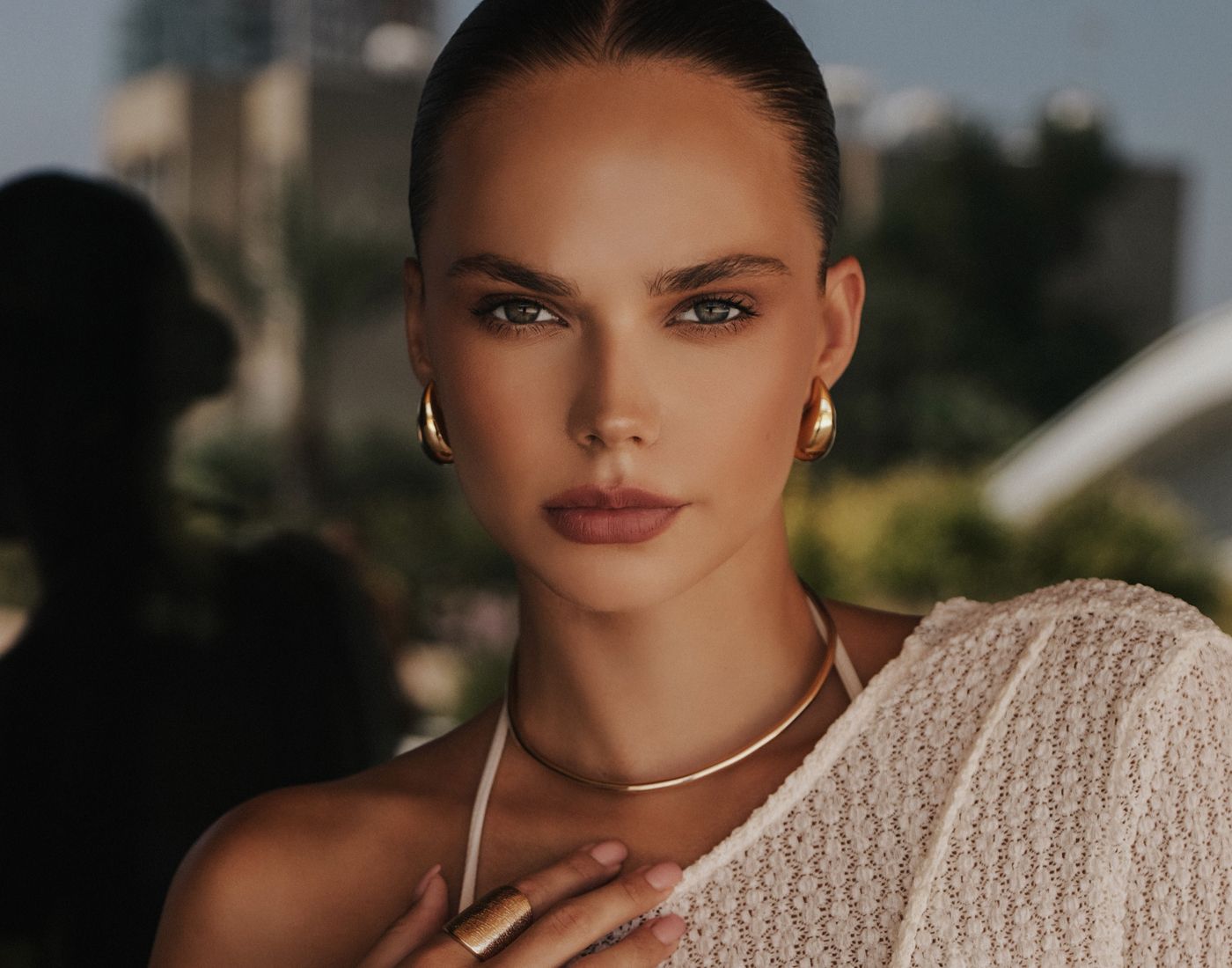 Model with elegant makeup and accessories outdoors.